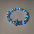 Detail van lichtgevende blauwe kralen en zeesterhanger aan een parelketting. - Blauw Lichtgevende Armband (11#)