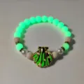 Close-up detail of a glow in the dark beach necklace with golden shell pendant - 12 # Golden green light bracelet
