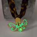 Close-up of luminous octopus pendant with gold trim and leopard print strap - Gold Green Glow Necklace