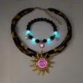 Detailed view of luminous beach jewelry set with gold sun pendant and glowing beads - Gold Rose Red Necklace Bracelet Set