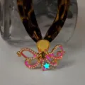 Close-up of gold octopus necklace with glowing star and leopard print strap - Gold Rose Red Glow Necklace