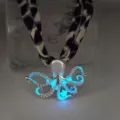 Close-up detail showing the glowing blue luminous effect of the octopus pendant metal - White K Blue Glow Necklace