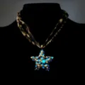 Detailed view of a luminous star pendant with a vintage leopard print fabric strap. - Necklace / Gold (Blue Light)