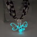 Detailed view of a luminous octopus pendant necklace glowing bright blue in a dark setting - White K Cyan Glow Necklace