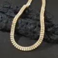 Detailansicht einer vergoldeten zweireihigen Strass-Halskette auf dunklem Stein. - Halskette / 40CM / Gold