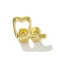 Dettaglio macro di grillz dentale hip-hop dorato con motivi a cuore e stella traforati. - Oro