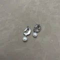 Dettaglio macro di orecchini a lava traforati retrò con eleganti ciondoli in perla - Argento