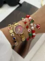 Vista dettagliata di un set orologio e braccialetto dorati a tema natalizio. - Set Quadrante Rosso Sfumato (889 Set 7)