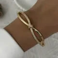 Vista detallada de un elegante brazalete de lazo dorado con micro-pavé de cristales. - Pulsera de Lazo de Circonia (BR26Y0355)