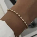 Vista macro de una delicada pulsera chapada en oro con cristales transparentes brillantes - Cadena de Fila de Circonia Ovalada (BR26Y0355)
