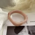 Dettaglio ravvicinato che mostra la trama marmorizzata del bracciale in acrilico rosa. - Rosa Acquerellato