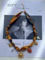 Gros plan d'un collier en ruban floral avec des breloques dorées soleil et coeur. - Style Tournesol (1423) / Style Tournesol