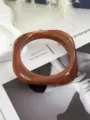 Detailansicht eines quadratischen Acryl-Armreifs mit bernsteinfarbener Marmorierung - Braun (2519)