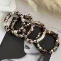 Dettaglio dei braccialetti retrò in acrilico maculato con perle e accenti dorati. - Set di Bracciali Curvi / Set Stampa Leopardata