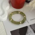 Vintage bamboe-stijl armband met groene harssegmenten en gouden metalen ringen - Retro Buisvormige Bamboe Stijl (232) / Inktwassing Groen