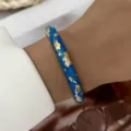 Elegante bracciale rigido boho in smalto blu con raffinati motivi floreali dorati - Rilievo Floreale Blu (885-4)