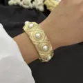 Eleganter Vintage-Armreif in Goldoptik mit Perleneinsätzen und feinen Mustern - Perlweiß