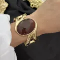 Vintage vergoldetes breites Manschettenarmband mit großem braunem ovalem Edelsteininlay - Wirbel Bernstein Geometrisch