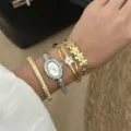 Dettaglio dell'orologio ovale con strass argento e set di bracciali a fiori dorati - Set Orologio e Bracciale 574 / Stile Argento