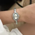 Vista ravvicinata di un orologio ovale color argento con lunetta in strass indossato al polso. - Orologio 574 / Stile Argento