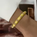 Close-up of a yellow enamel bangle featuring pink flower patterns for a summer look - Yellow Enamel Pink Flower (883-1)