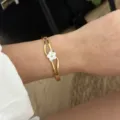 Elegante bracciale rigido dorato con un delicato fiore bianco e brillanti accenti in cristallo - Bracciale Fiore Bianco A230 / Oro/Bianco