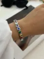 Bracciale in argento con pietre preziose rotonde multicolori su un polso femminile - A852银