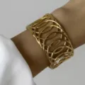 Bracciale rigido largo in acciaio inossidabile dorato con design a ovali traforati - Stile a Cerchi Collegati