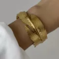 Bracciale rigido aperto a piuma dorata testurizzata in acciaio inossidabile da donna - Stile Piuma