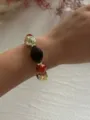 Nahaufnahme eines Vintage-Armbands mit marmorierten Acryl- und goldenen CCB-Perlen am Handgelenk. - Orange & Braun & Gold