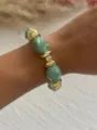 Nahaufnahme von klobigen grünen Marmor-Acrylperlen und goldenen Akzenten am Armband - Tie-Dye-Grün & Gold