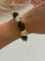 Nahaufnahme eines Armbands mit unregelmäßigen Acrylperlen und goldenen geometrischen Perlen - Olivgrün + Gold