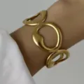 Bracciale rigido dorato opaco strutturato con ritagli organici a effetto onde d'acqua - Cavo Irregolare