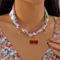 Close-up detail of cherry pendants on floral silk ribbon choker necklace for women - Strawberry Cherry Pendant (NC25Y1033-6) / Light Pink