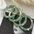 Elegante set di bracciali in acrilico verde bohémien con accenti dorati e perle bianche - Set di Bracciali Curvi / Set con Zirconia Verde