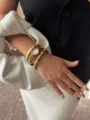 Macro detail view of gold angular watch and crystal-embellished elastic bracelets on wrist - Watch And Bracelet Set / Gold/White Dial