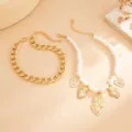 Detailansicht eines Schmucksets aus Perlen und Goldkette mit Heilig-Herz-Anhängern. - Gold Set