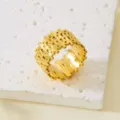 Detailansicht eines vergoldeten Edelstahlrings mit unregelmäßiger geometrischer Textur. - Fence (418) / Gold