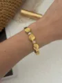 Dettaglio del braccialetto in acciaio dorato con conchiglie e perle indossato al polso - Bracciale Rigido Conchiglia Perla Artificiale (A281) / Oro