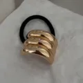 Primo piano dettagliato di un elastico per capelli minimalista in lega d'oro su pietra - Fermaglio Curvo a Tre Strati (2025397) / Oro