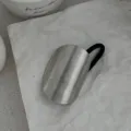 Detail einer minimalistischen silbernen Haarmanschette mit schwarzem Gummiband auf Textur - Matte Gebogene Manschette (2025397) / Silber
