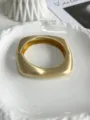 Detailed close-up of a geometric matte gold wavy bangle with brushed metal texture finish - Irregular Square Style (Matte Gold 04) / Matte Gold 04