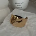 Detailansicht einer unregelmäßig gehämmerten goldenen Haarspange mit schwarzem Gummiband - Gehämmerte Unregelmäßige Haarmanschette (2025397) / Gold