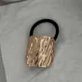 Elegantes schwarzes Haargummi mit einem großen vergoldeten gehämmerten Metallelement. - Gehämmerte Quadratische Manschette (2025397) / Gold