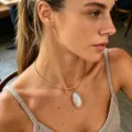 Detail view of a gold-finish minimalist choker necklace with an irregular amber pendant - Torque Necklace (7950) / White