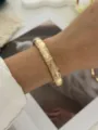 Vintage goldfarbener Armreif mit einzigartiger Bambustextur am Handgelenk des Modells - Goldene Vertikale Bambustextur (A829-9)