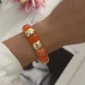 Orangefarbenes Harzperlenarmband mit Vintage-Goldperlen auf Modellhandgelenk - Hellorange (824 Orange)