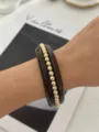 Elegante bracciale vintage in smalto bordeaux con perline dorate di alta qualità. - Perla Dorata Caffè