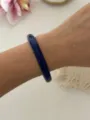 Eleganter, tiefblauer schmaler runder Harzarmreif am Handgelenk in Lifestyle-Umgebung - Dünner Runder Stil / Lila