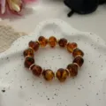 Elegantes bernsteinfarbenes Armband mit unregelmäßigen Perlen und goldenen Akzenten. - Unregelmäßiger Perlenstil (823) / 13 Stück (10mm) / Transparent Kaffee